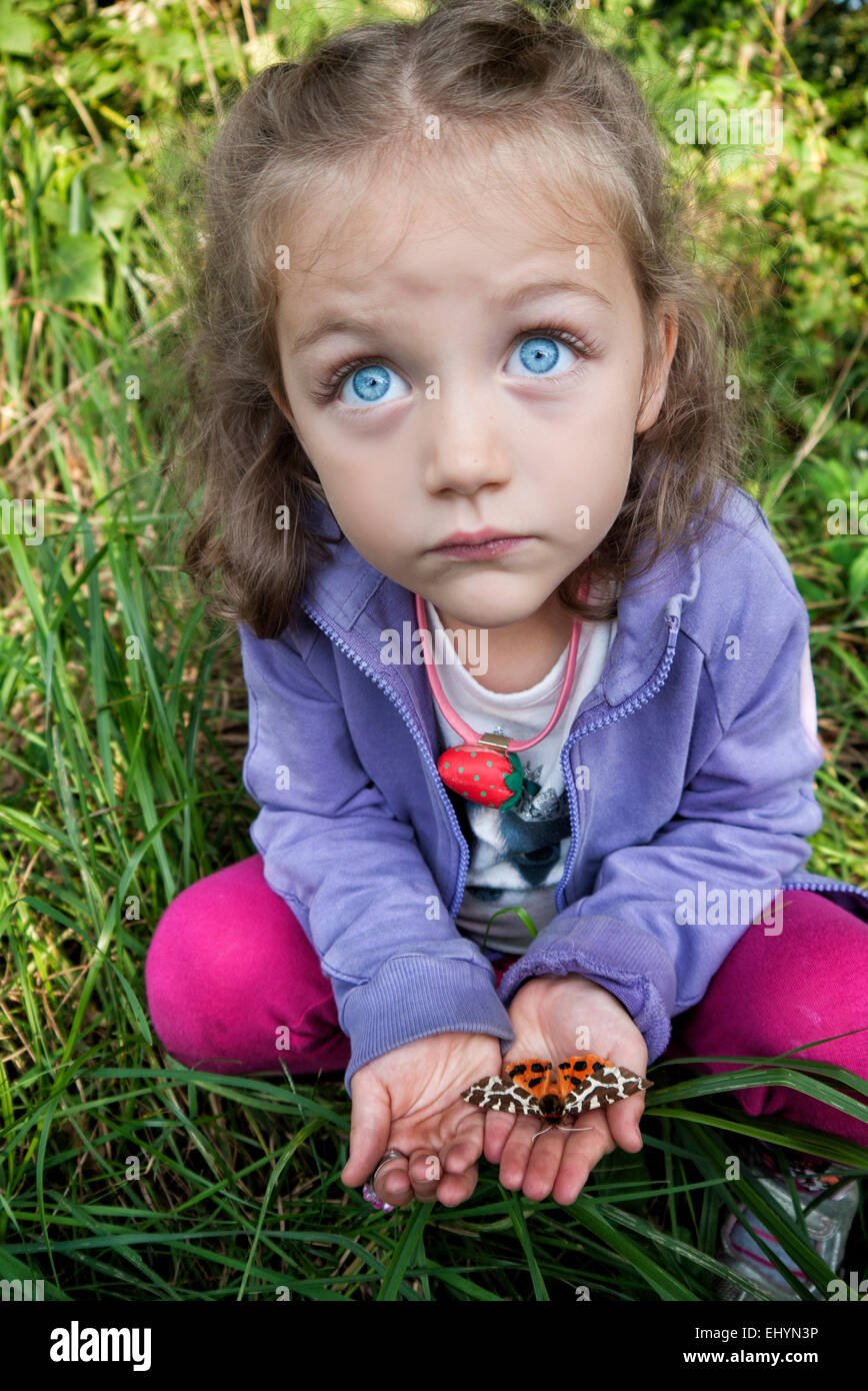 Girl holding une espèce dans la paume de ses mains Banque D'Images