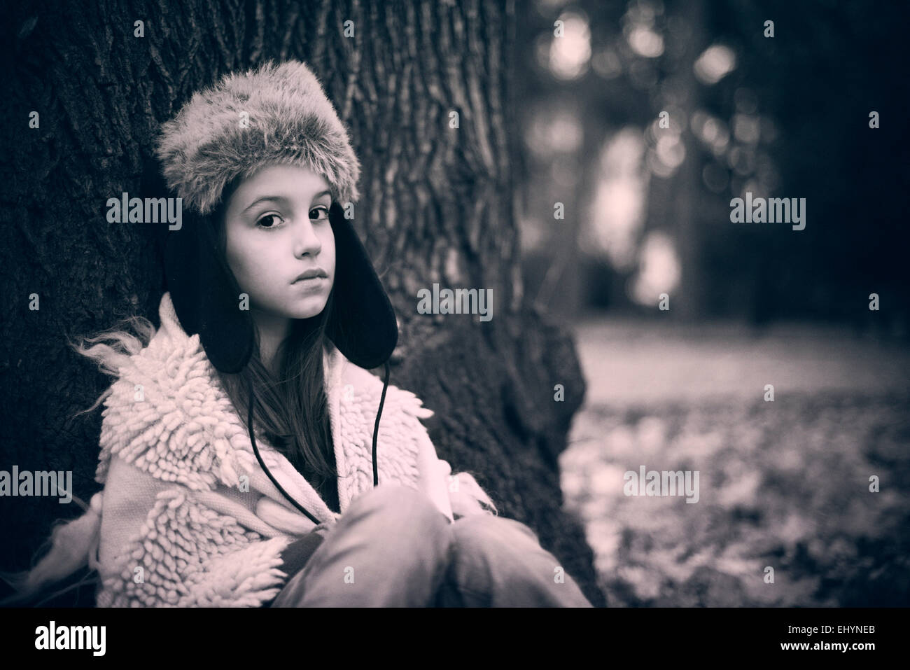 Sad girl appuyé contre un arbre Banque D'Images