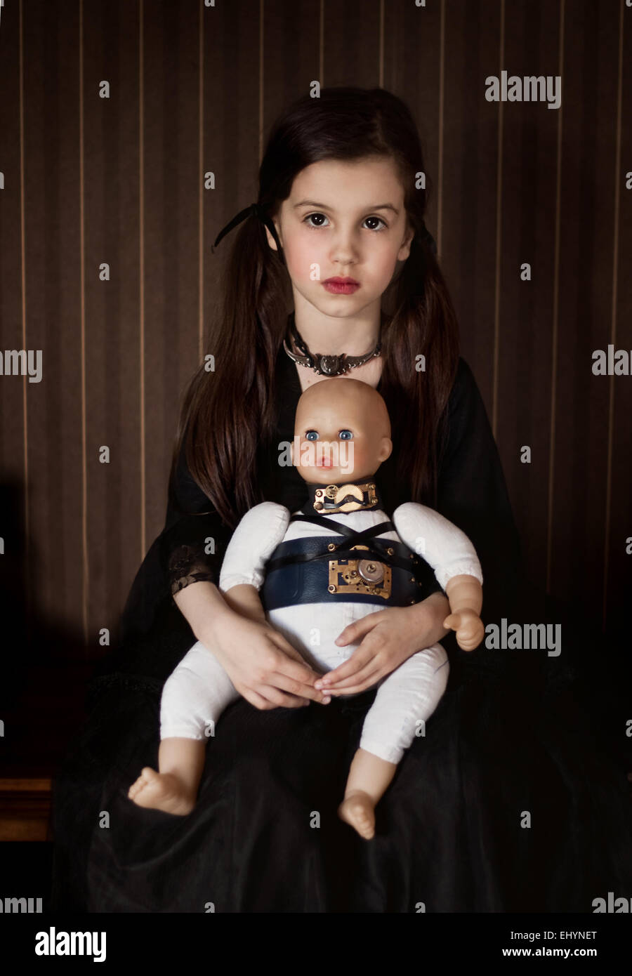 Fille assise avec une poupée avec accessoires steampunk Banque D'Images