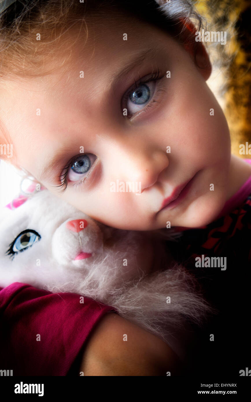 Portrait d'une fille qui câline un jouet doux de chat Banque D'Images