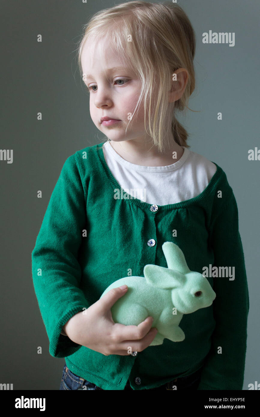 Portrait d'une fille tenant un jouet de lapin coudly Banque D'Images