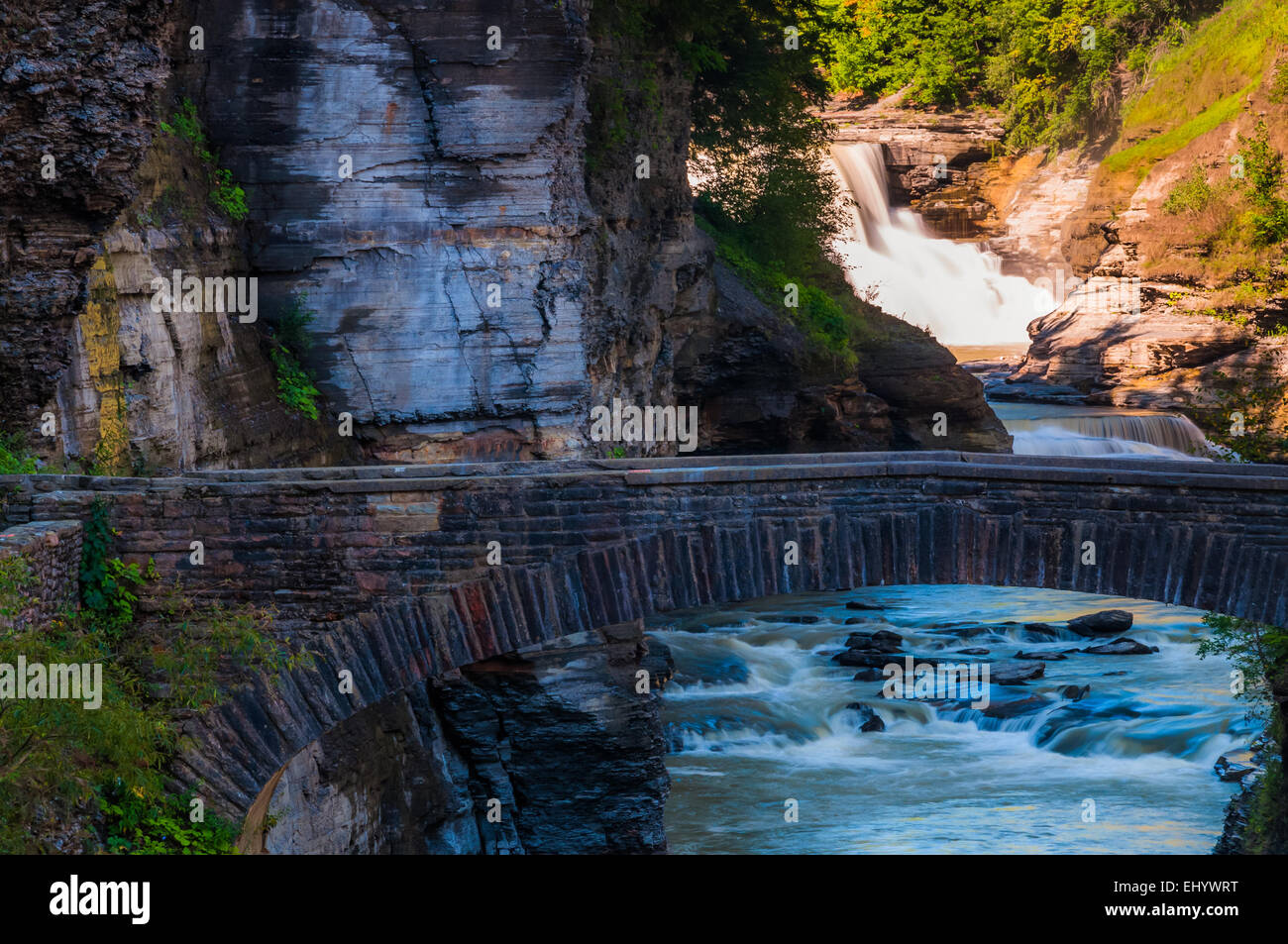 Lower Falls et un pont pour piétons à travers la gorge de la rivière Genesee, Letchworth State Park, New York. Banque D'Images