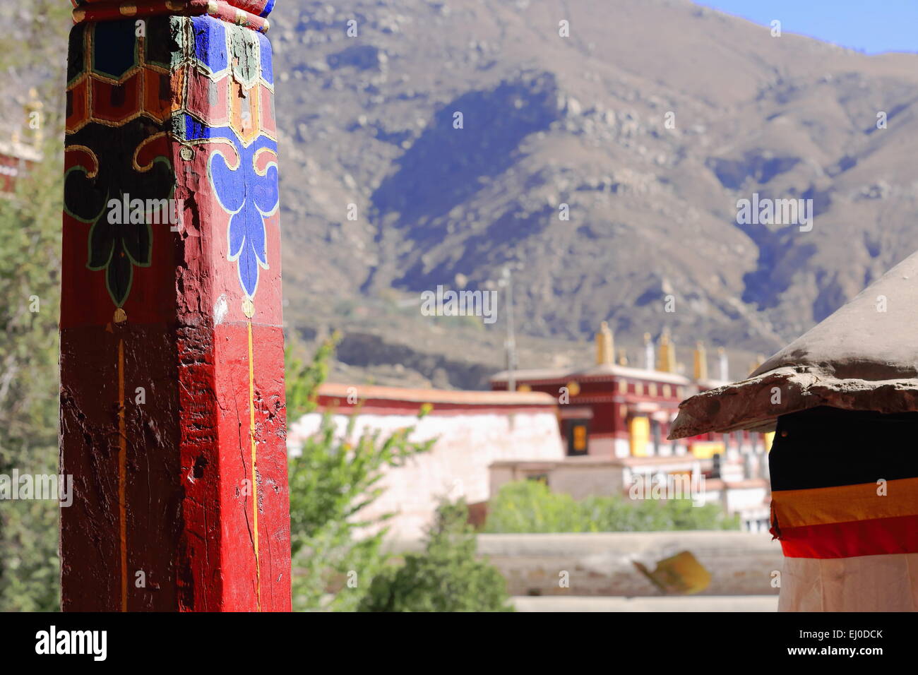 Piliers en bois peint rouge-clorist dessins-vue sur les toits de la montagne. Drepung-Rice Heap monastère de l'ordre Gelugpa. Banque D'Images