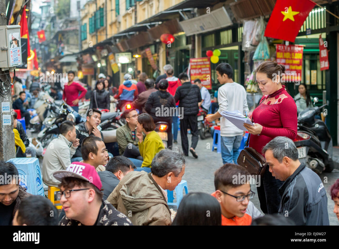 Serveuse vietnamien prend les commandes à un restaurant en plein air dans le vieux quartier de Hanoi Banque D'Images