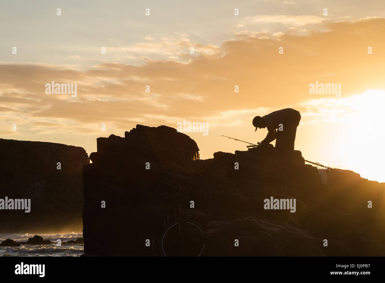 Préparation au démarrage de pêcheur à la pêche tôt le matin sous le lever du soleil Banque D'Images