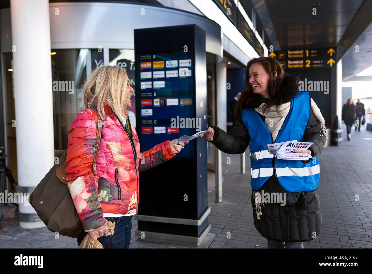 Copenhague, Danemark, le 19 mars 2015 : l'aéroport de travailleur (R) Distribuer flyer's à l'extérieur du Terminal 2 à l'aéroport de Copenhague pour protester contre que Ryanair ne sera pas en conformité avec les accords locaux. À partir du 26 mars l'entreprise d'établir une base située à Copenhague et élargit les vols de Danemark : OJPHOTOS Crédit/Alamy Live News Banque D'Images