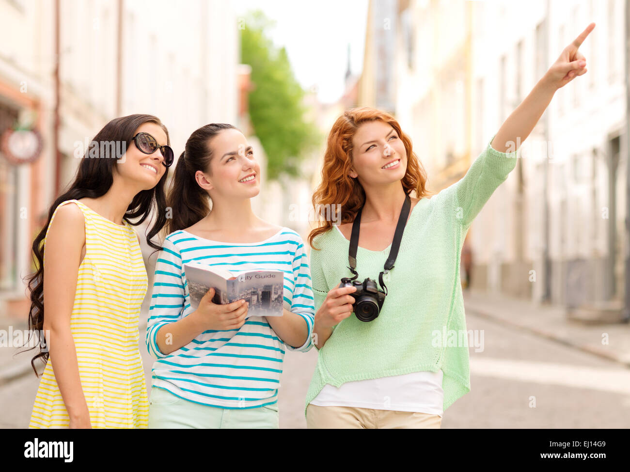 Smiling teenage girls avec guide de la ville et de l'appareil photo Banque D'Images