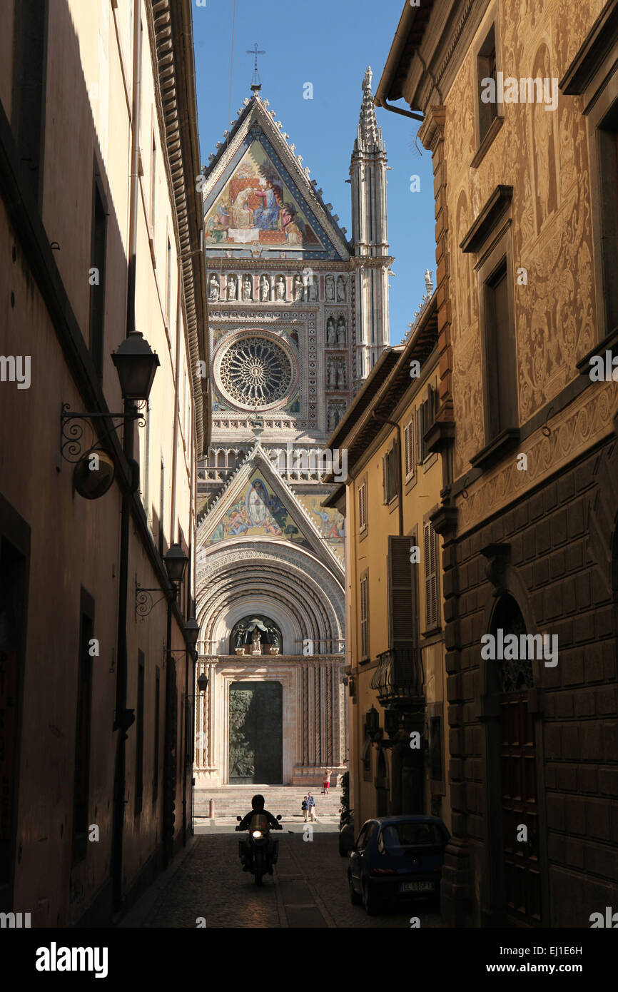 Acreoos Scooter va l'étroite rue en face de la cathédrale (Duomo di Orvieto Orvieto) à Orvieto, Ombrie, Italie. Banque D'Images
