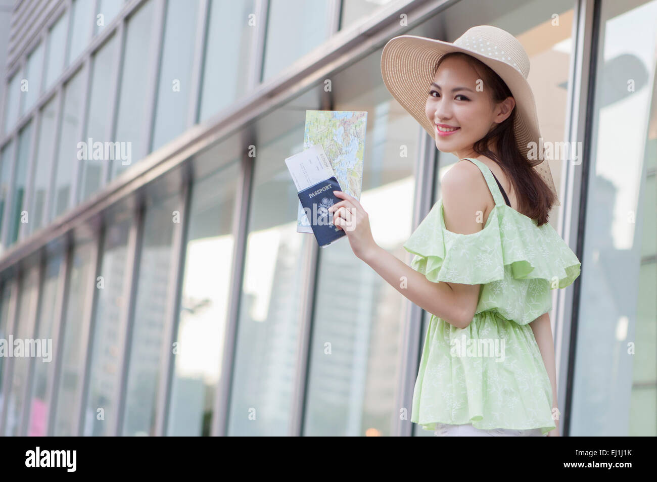 Young woman holding passeport et billet d'avion avec le sourire, Banque D'Images