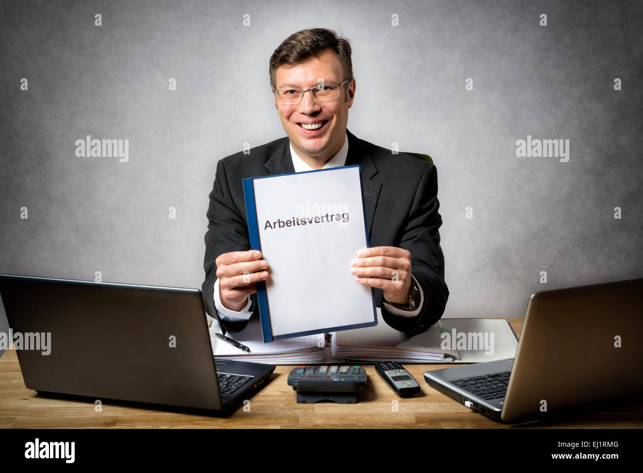 Businessman au bureau 24 est titulaire d'un contrat de travail avec l'allemand 'Titre' Arbeitsvertrag Banque D'Images