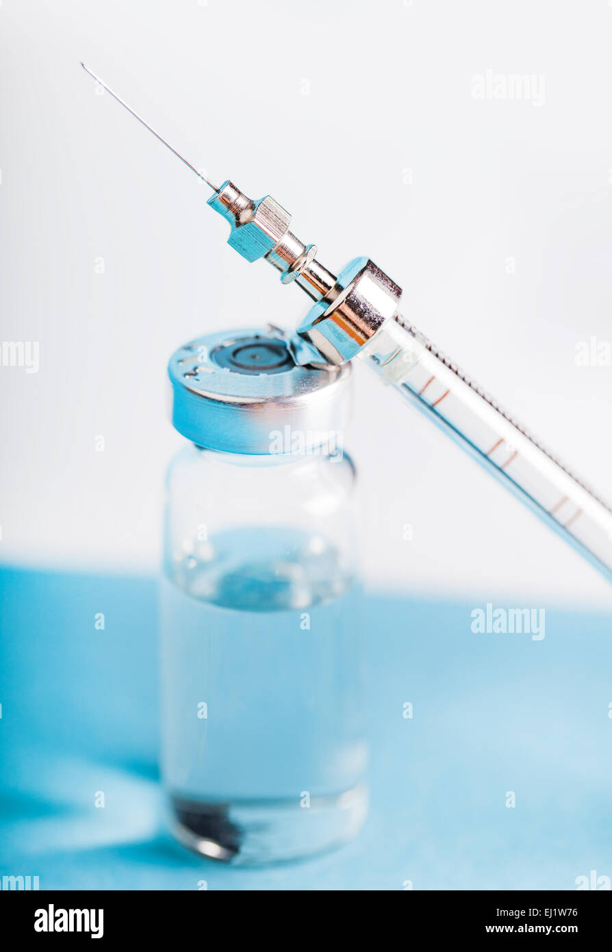 Bouteille de médicament et d'une seringue sur un fond bleu Banque D'Images