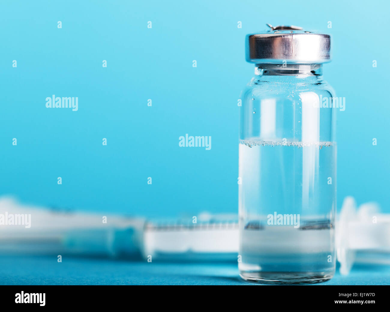Bouteille de médicament et d'une seringue sur un fond bleu Banque D'Images
