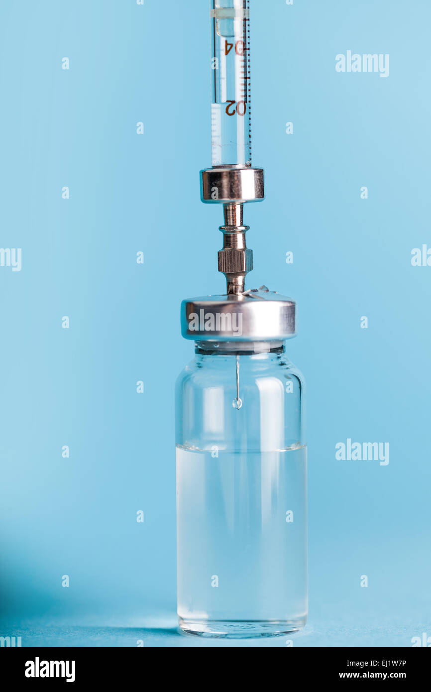 Flacon de médicaments et seringue gros plan sur un fond bleu Banque D'Images