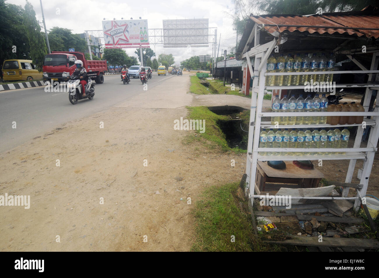 Le carburant pour les mobylettes ('benzin') vendus dans des bouteilles d'eau en plastique à côté de la route principale, Sorong, la Papouasie occidentale, en Indonésie. Pas de monsieur ou PR Banque D'Images