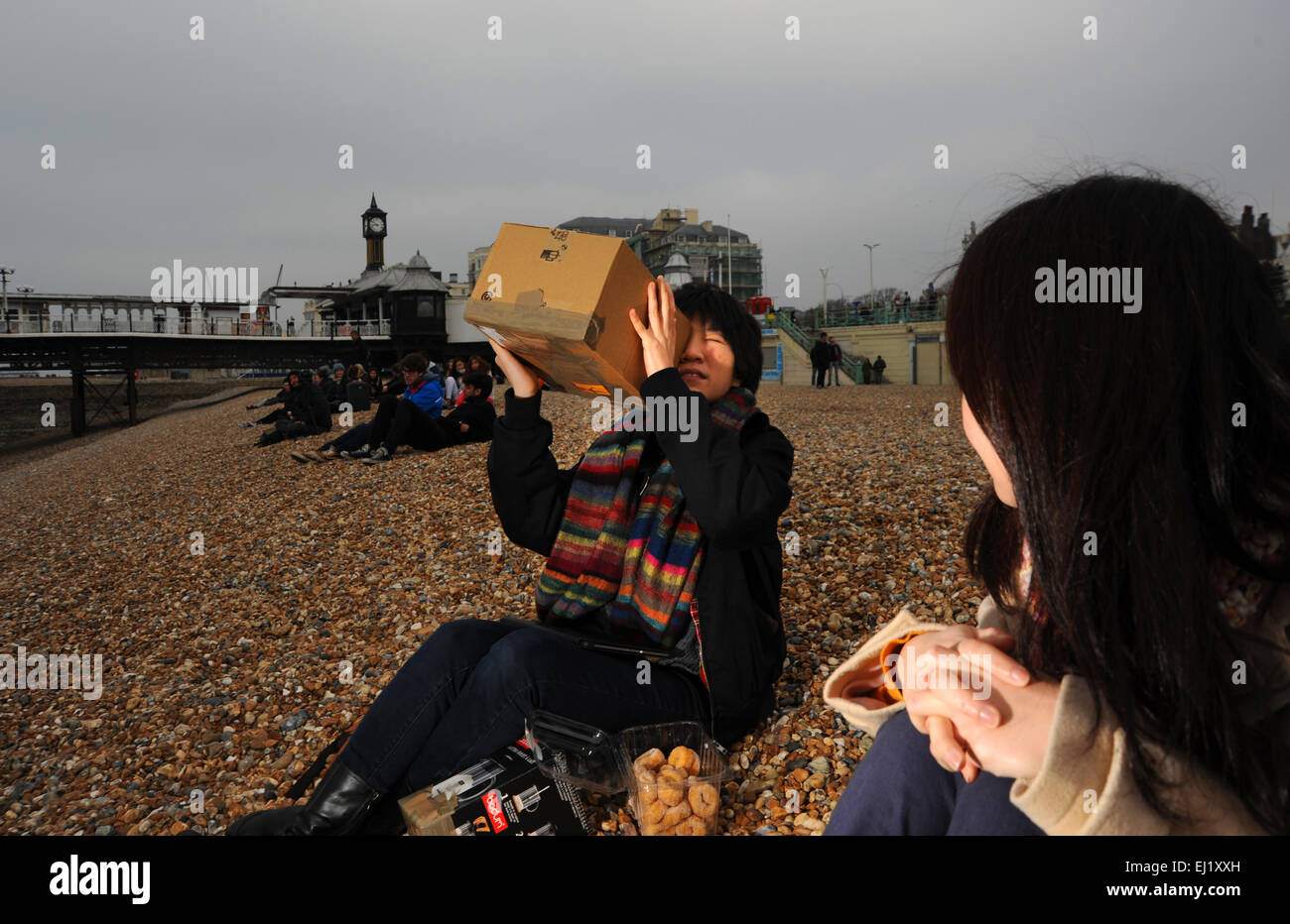Brighton Sussex UK 20 mars 2015 - Les gens sur la plage de Brighton ce matin pour voir l'éclipse solaire partielle du soleil qui se déroule tout au long de la Grande-Bretagne . Malheureusement, les conditions météorologiques étaient couvert et nuageux et quelques aperçus étaient possibles sur la côte sud Crédit : Simon Dack/Alamy Live News Banque D'Images