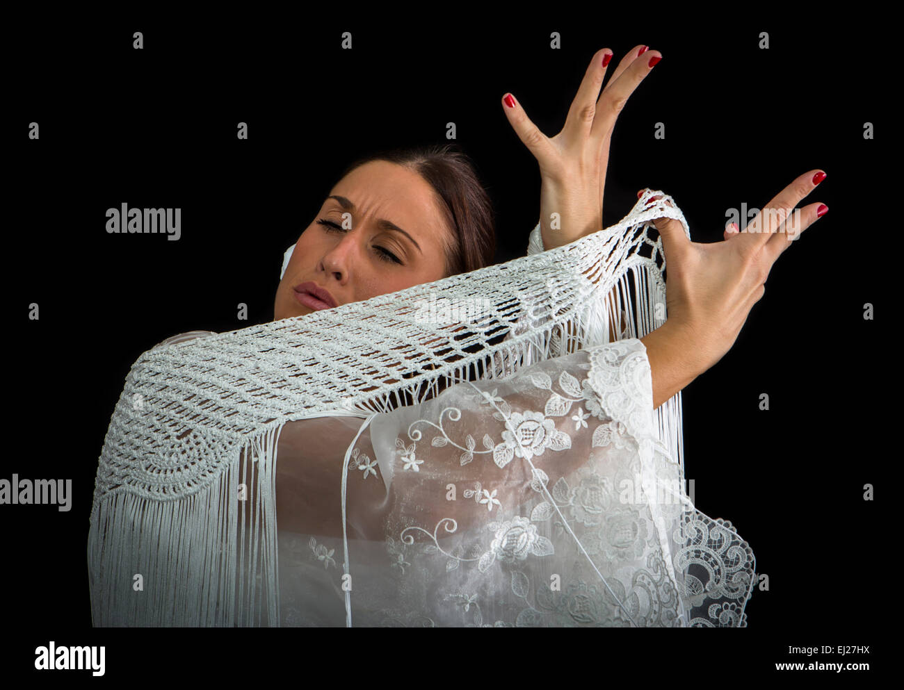 Danseuse de Flamenco avec robe blanche et mains croisées sur le dos sur fond noir Banque D'Images