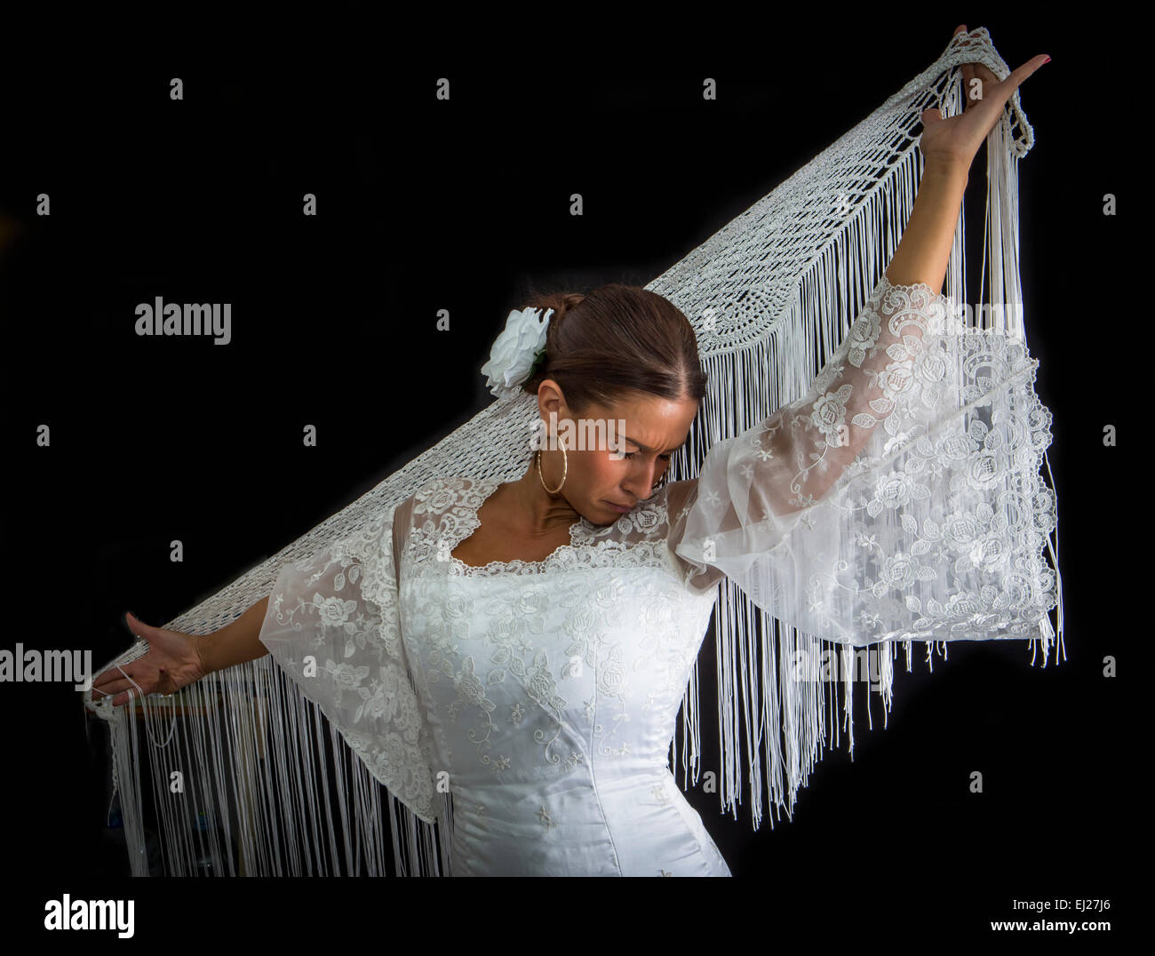 Danseuse de Flamenco avec robe blanche et mains croisées sur le dos sur fond noir Banque D'Images