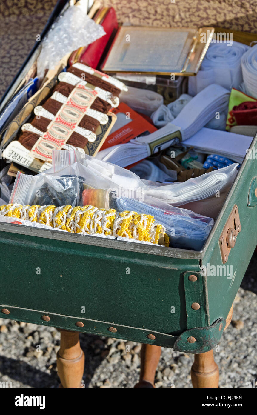 Une valise vintage remplie de notions de couture et garniture en un marché aux puces à Gigny-safe-Saône, Bourgogne, France. Banque D'Images