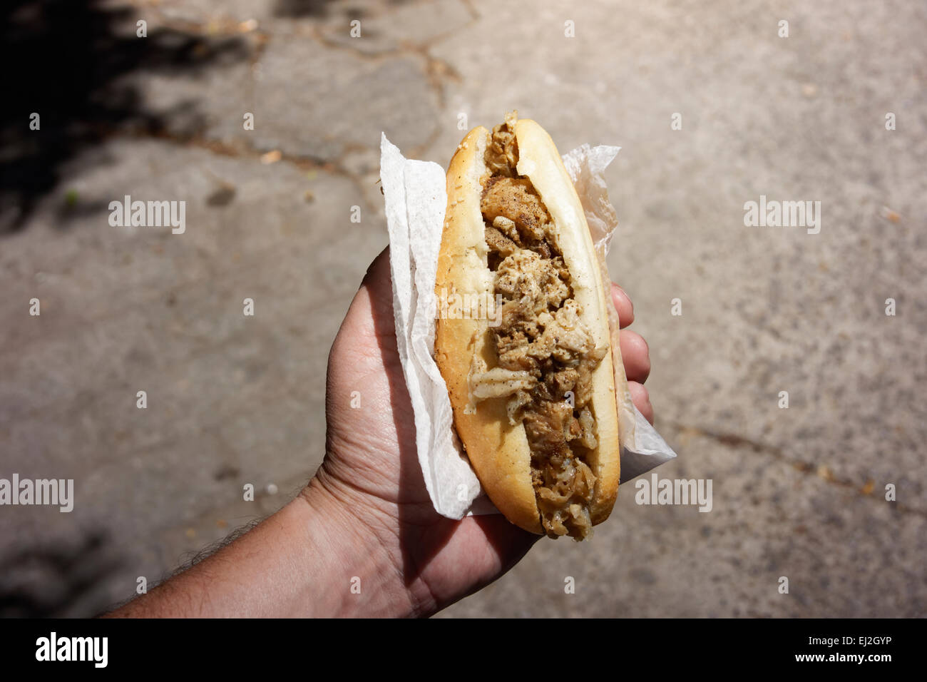 Palerme, Sicile. Capo marché. Man holding frittola sandwich. Banque D'Images