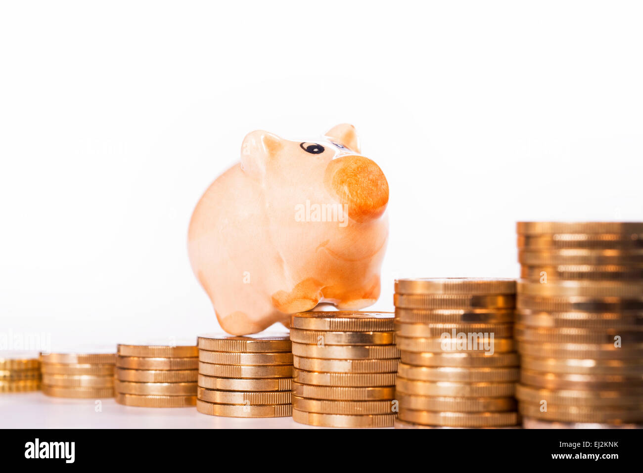 Tirelire debout sur des piles de pièces. Banque D'Images