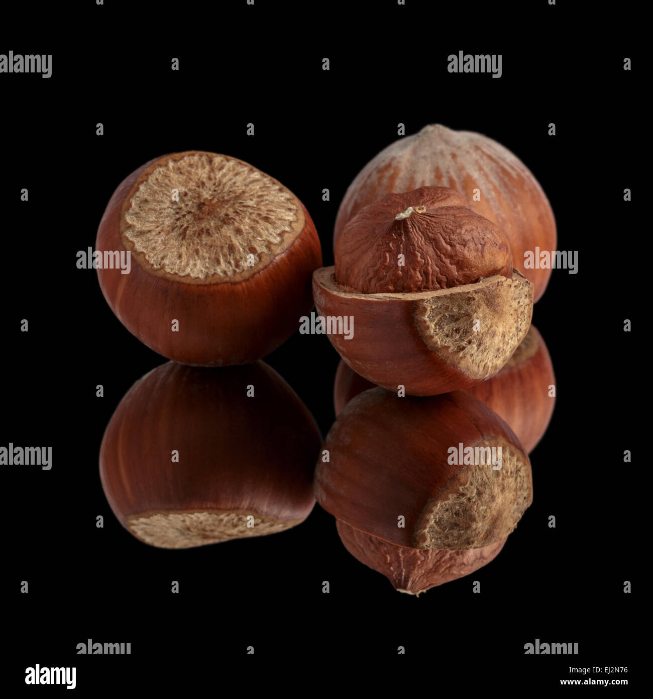 Trois noisettes sur miroir, isolé Banque D'Images