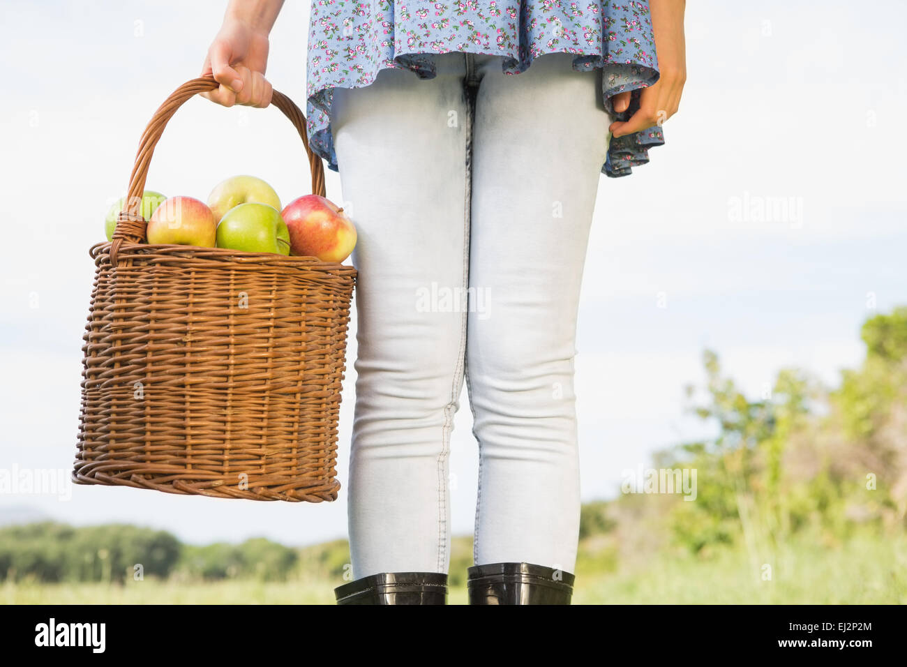 Woman holding basket of apples Banque D'Images