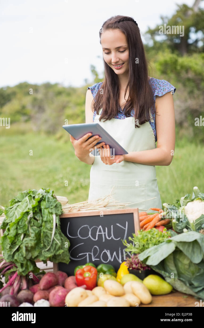 Femme vendant des légumes biologiques au cours du marché Banque D'Images