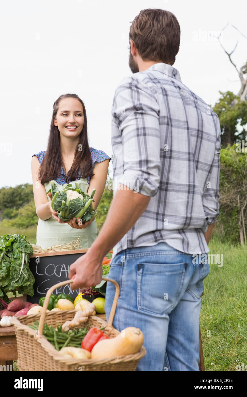 Femme vendant des légumes biologiques au cours du marché Banque D'Images