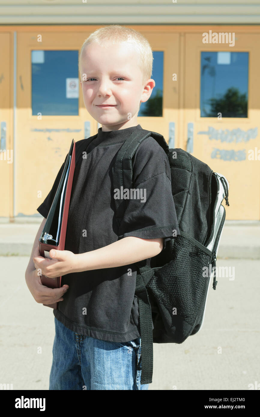 Garçon sur le terrain de son école avec un backpak Banque D'Images