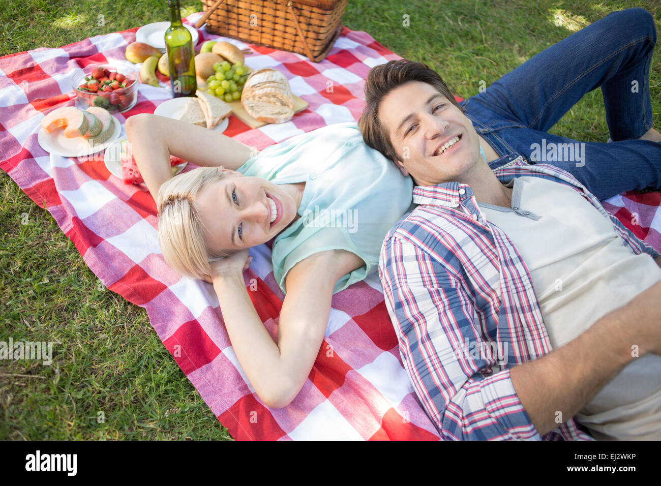 Heureux couple lying together at the park Banque D'Images