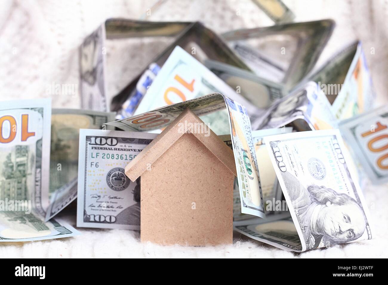 Maison jouet en bois - le concept de l'achat du logement de l'argent comptant en dollars de prêts hypothécaires Banque D'Images