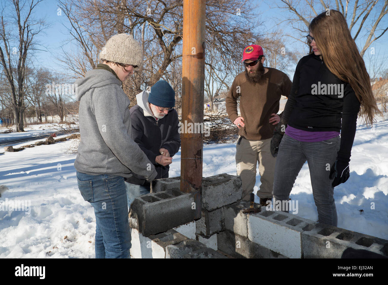 Detroit, Michigan - les agriculteurs urbains construction d'un poêle à bois extérieur temporaire pour faire bouillir la sève des arbres d'érable à sucre pour faire du sirop. Banque D'Images