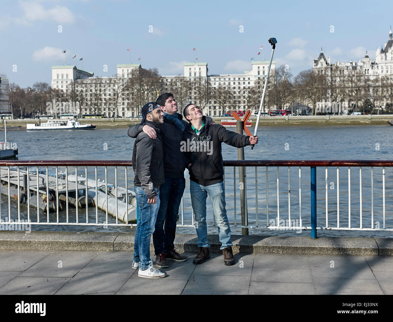 Trois jeunes garçons en tenant un bâton selfies sur pic à Southbank Banque D'Images
