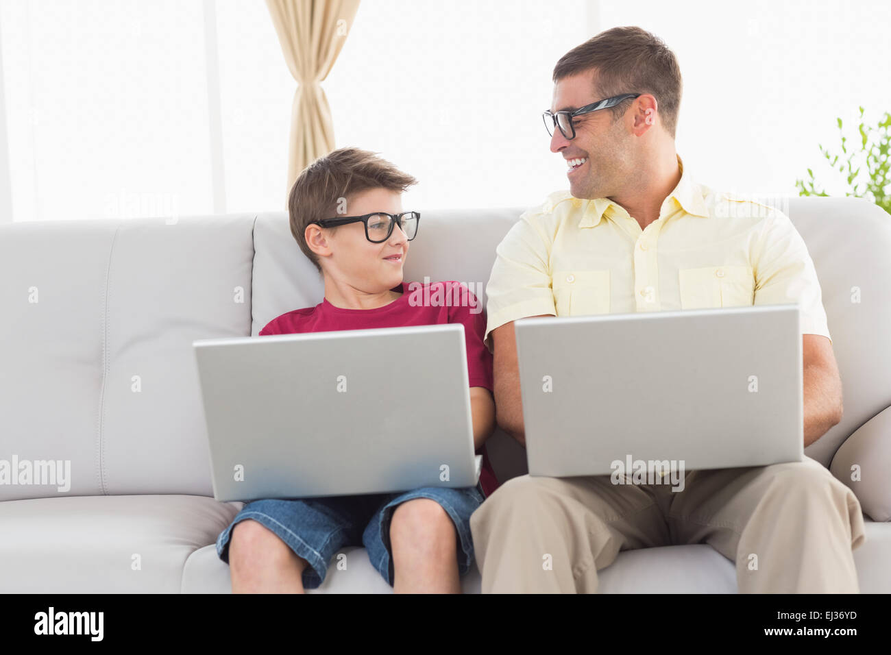 Père et fils se regarder pendant l'utilisation d'ordinateur portable Banque D'Images