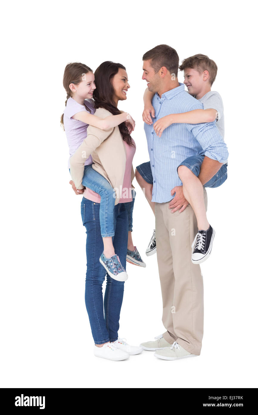 Vue de côté les parents qui piggyback ride aux enfants Banque D'Images