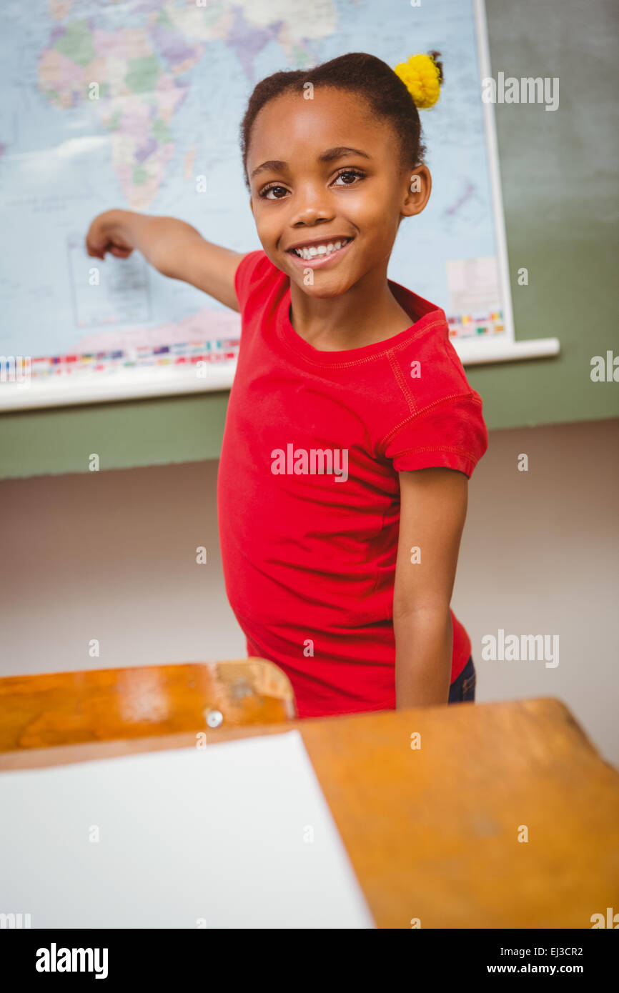 Girl pointing at map in classroom Banque D'Images