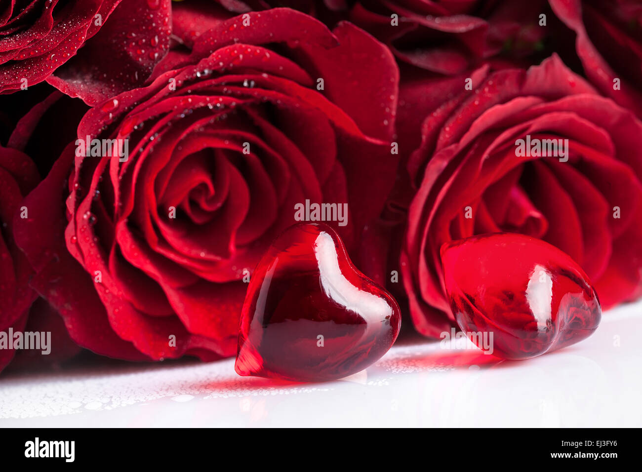 Fleurs roses rouges et deux coeurs, point sur le premier plan Banque D'Images