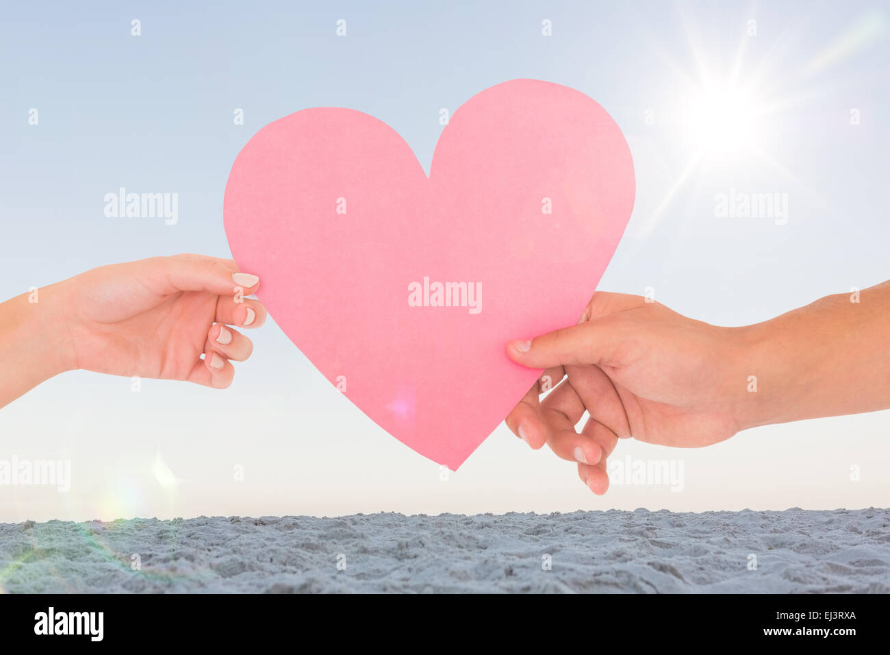 Image composite du couple passant un coeur de papier Banque D'Images