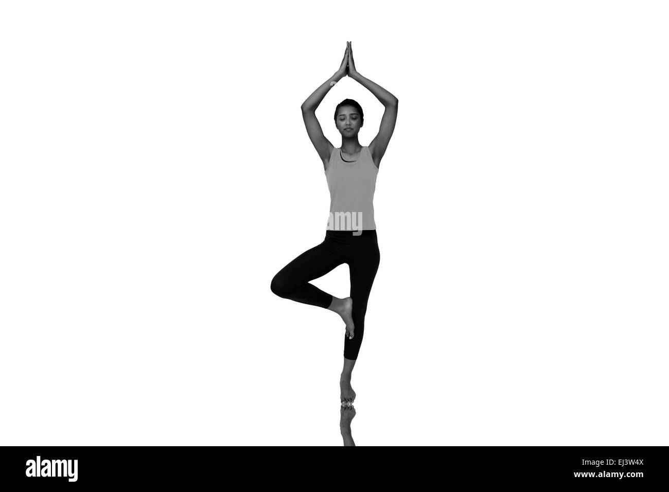 Composite image of a fit woman standing in posture de l'arbre Banque D'Images