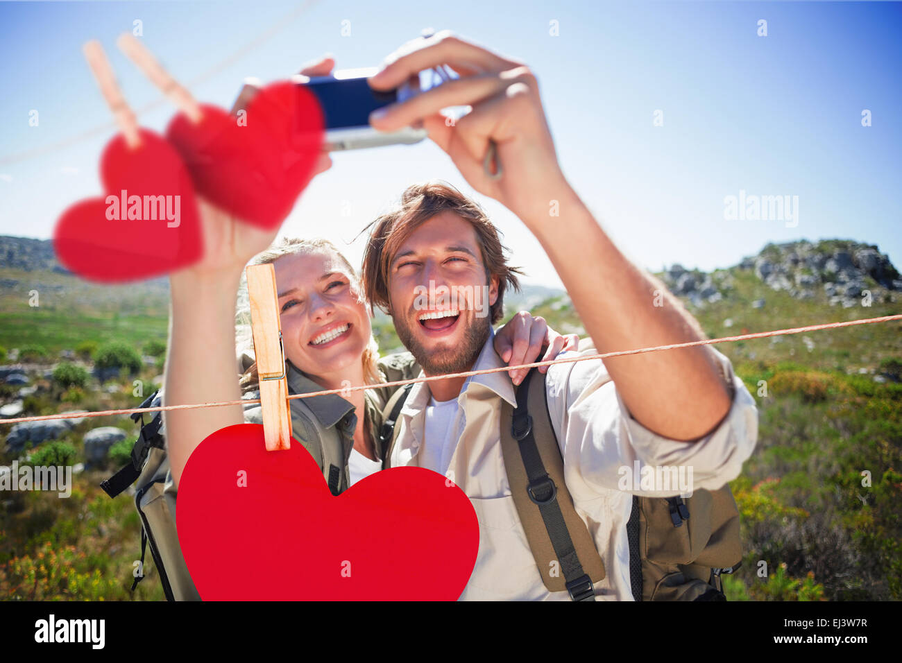 Image composite de randonnées couple standing sur terrain de montagne prenant un selfies Banque D'Images