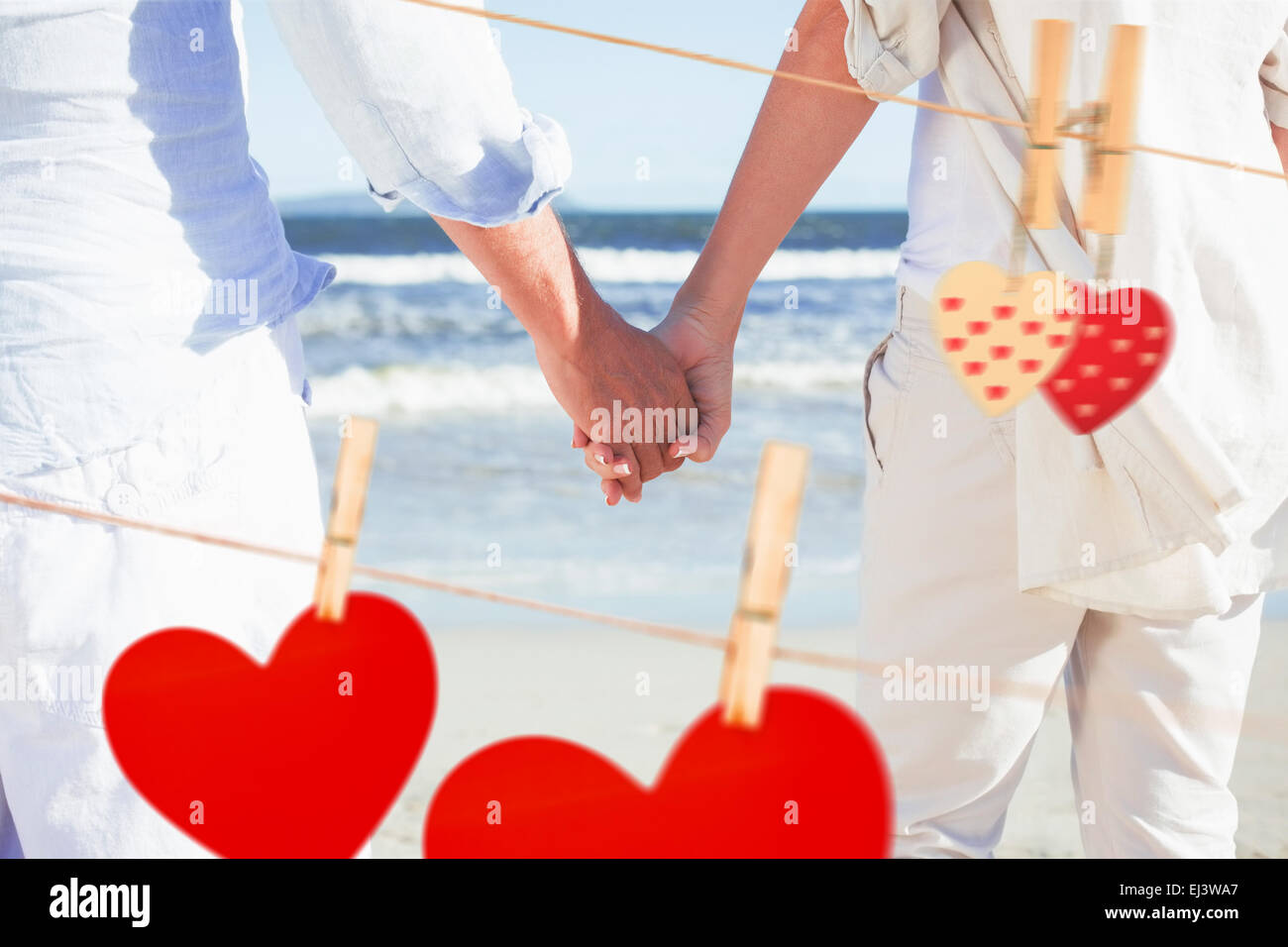 Image composite de couple sur la plage face à la mer holding hands Banque D'Images