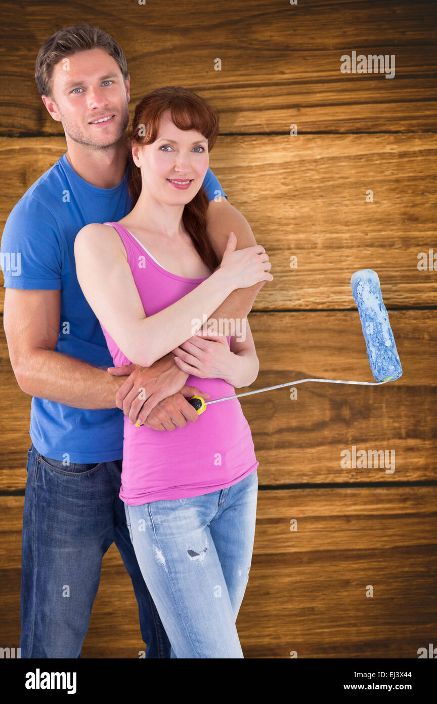 Image composite du couple hugging and holding brush Banque D'Images