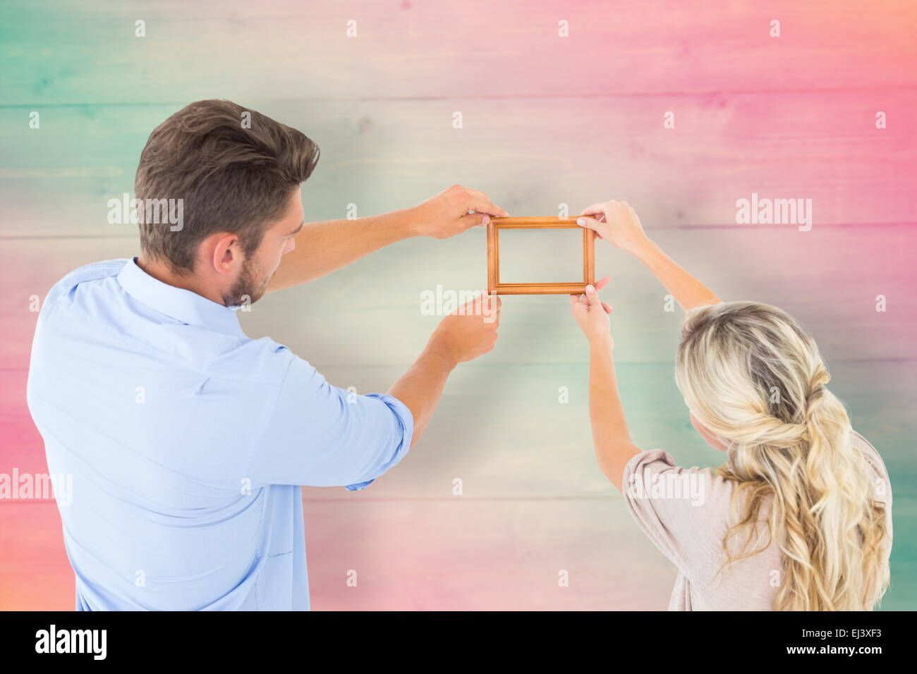 Composite image jeune couple accroché un cadre Banque D'Images