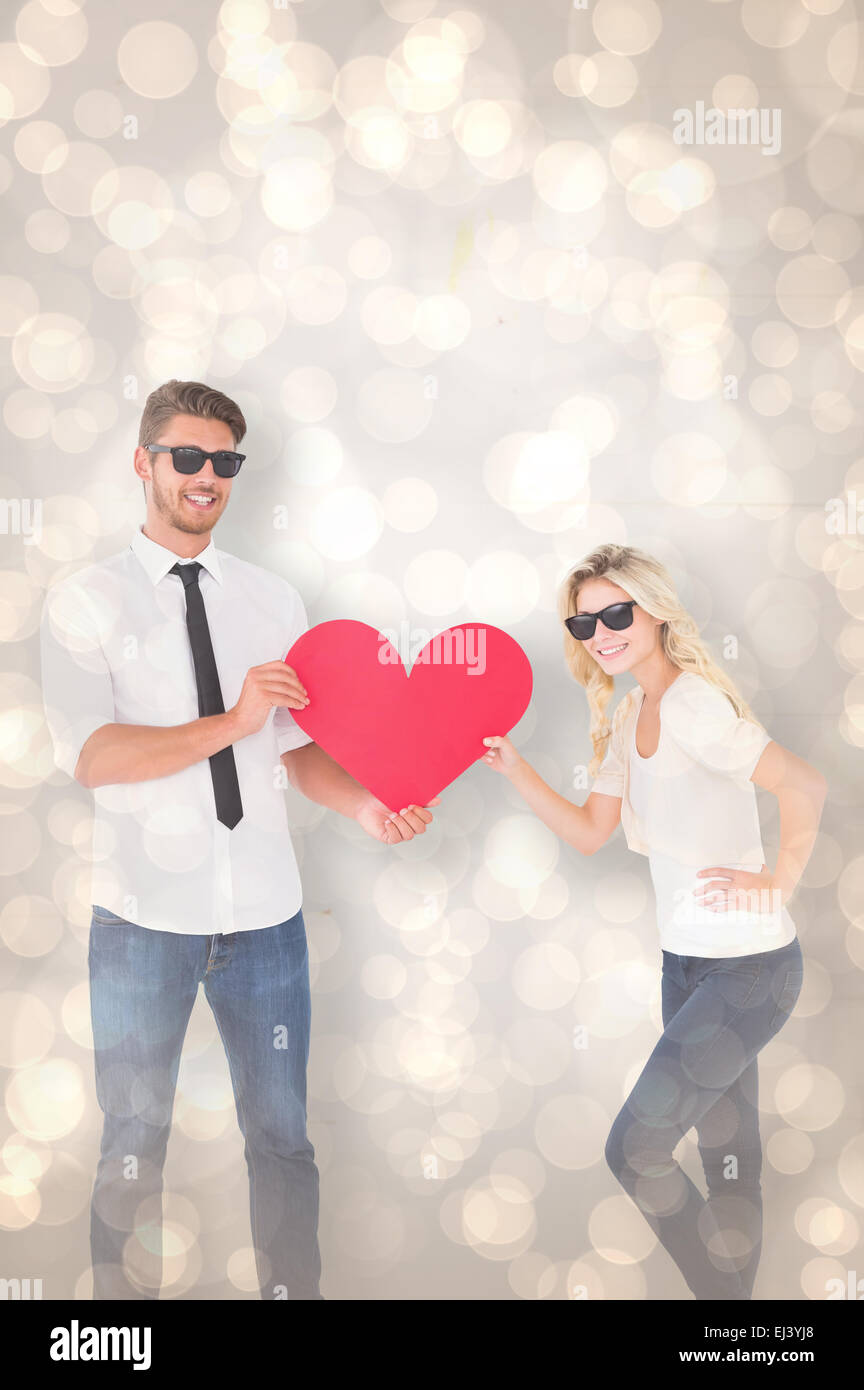 Image composite de cool young couple holding red heart Banque D'Images