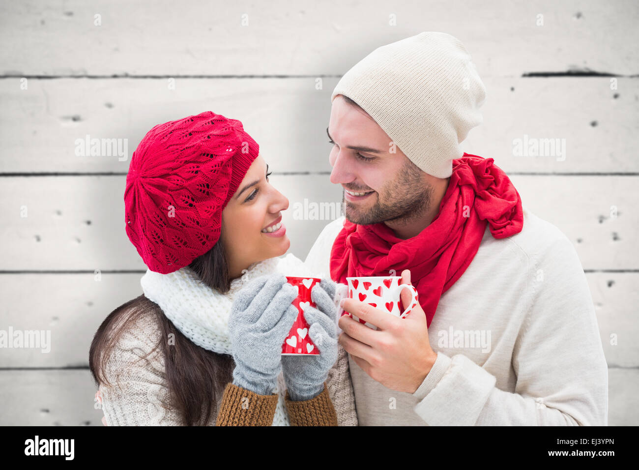 Image composite de l'hiver couple holding mugs Banque D'Images