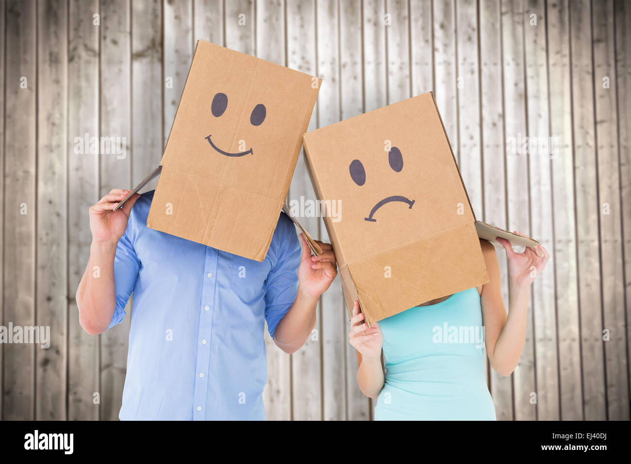 Image composite du couple wearing visage triste des boîtes sur leur tête Banque D'Images