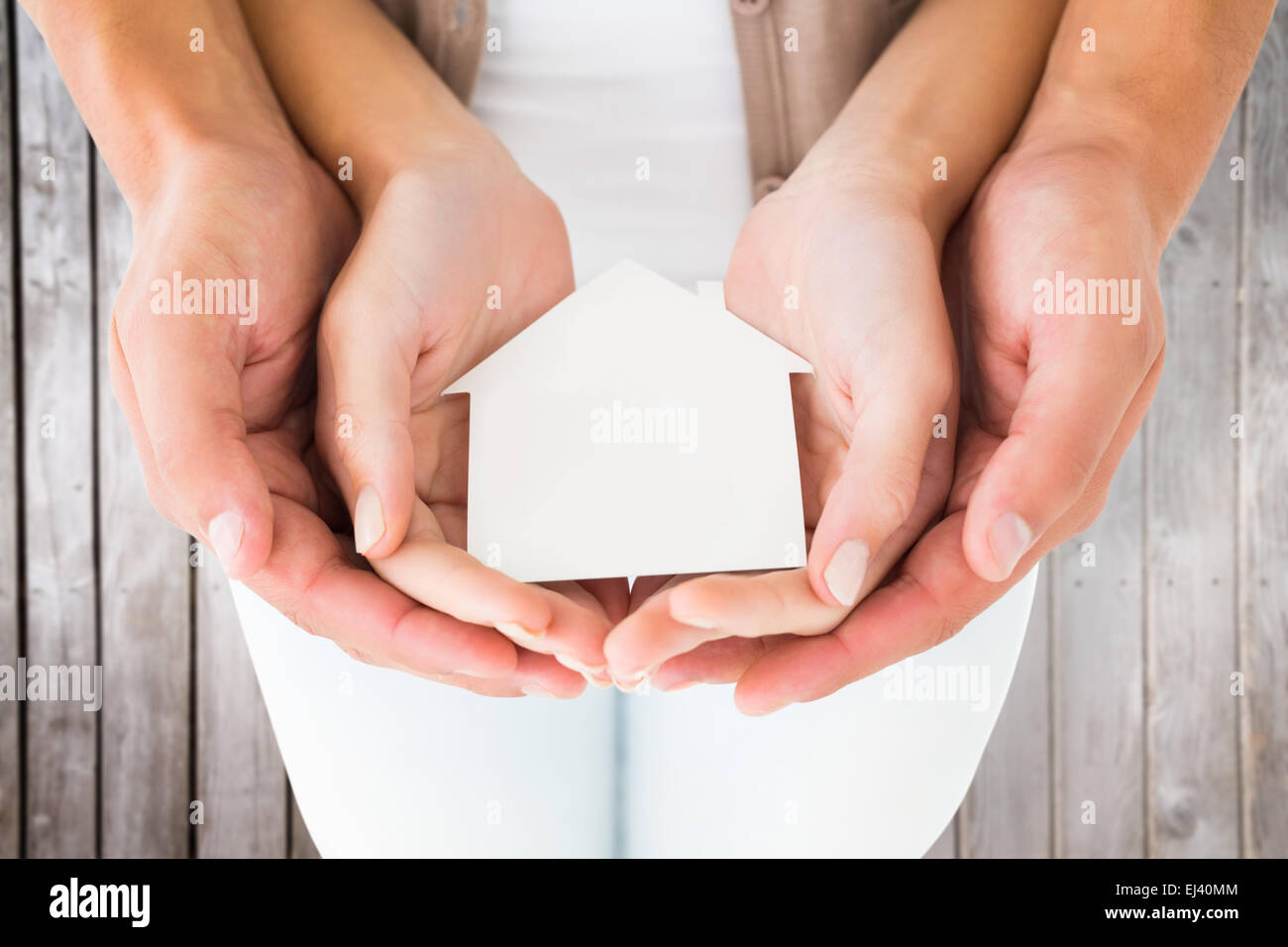 Image composite du couple holding miniature house in hands Banque D'Images