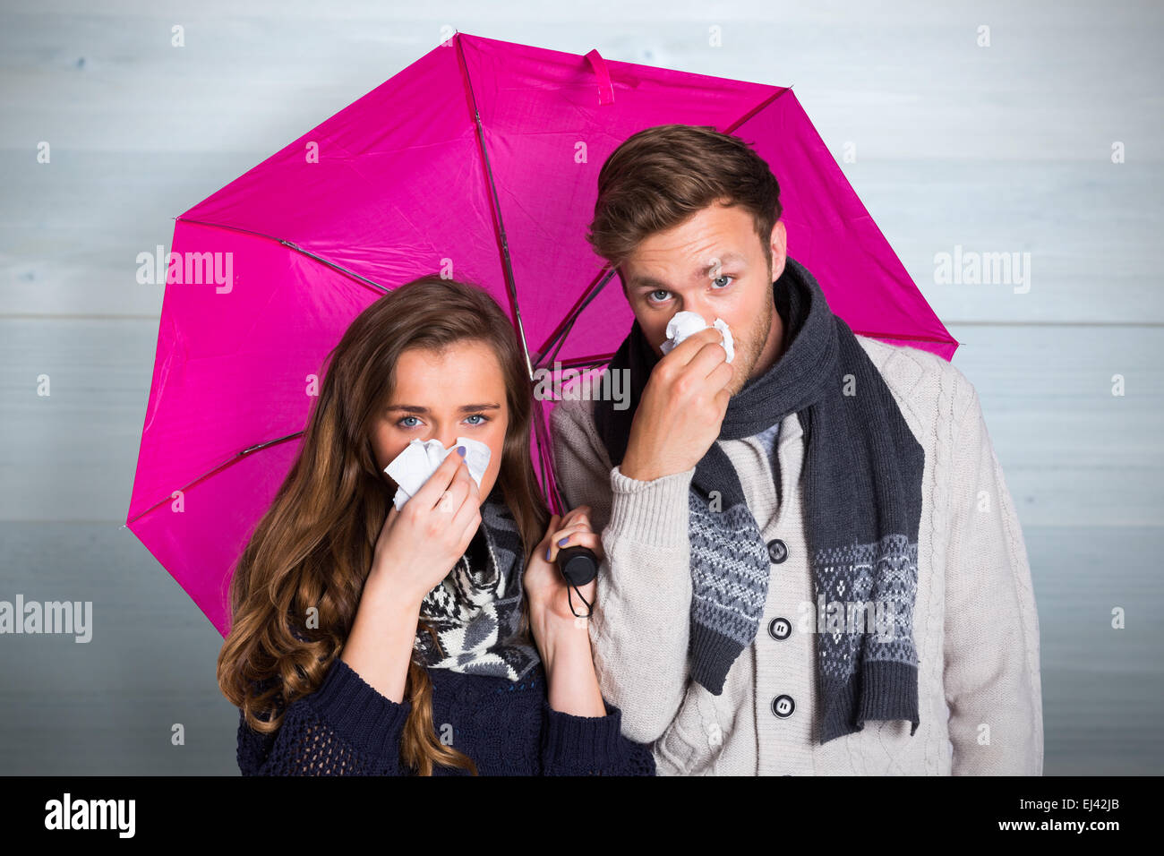 Image composite du couple blowing nose alors que holding umbrella Banque D'Images