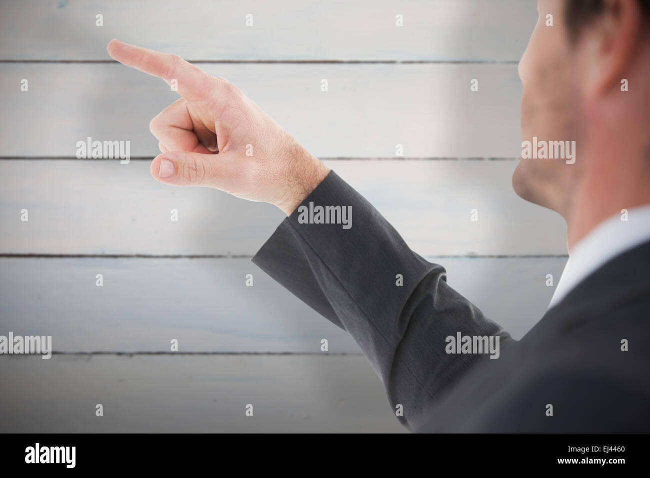 Image composite de handsome businessman pointing at something Banque D'Images