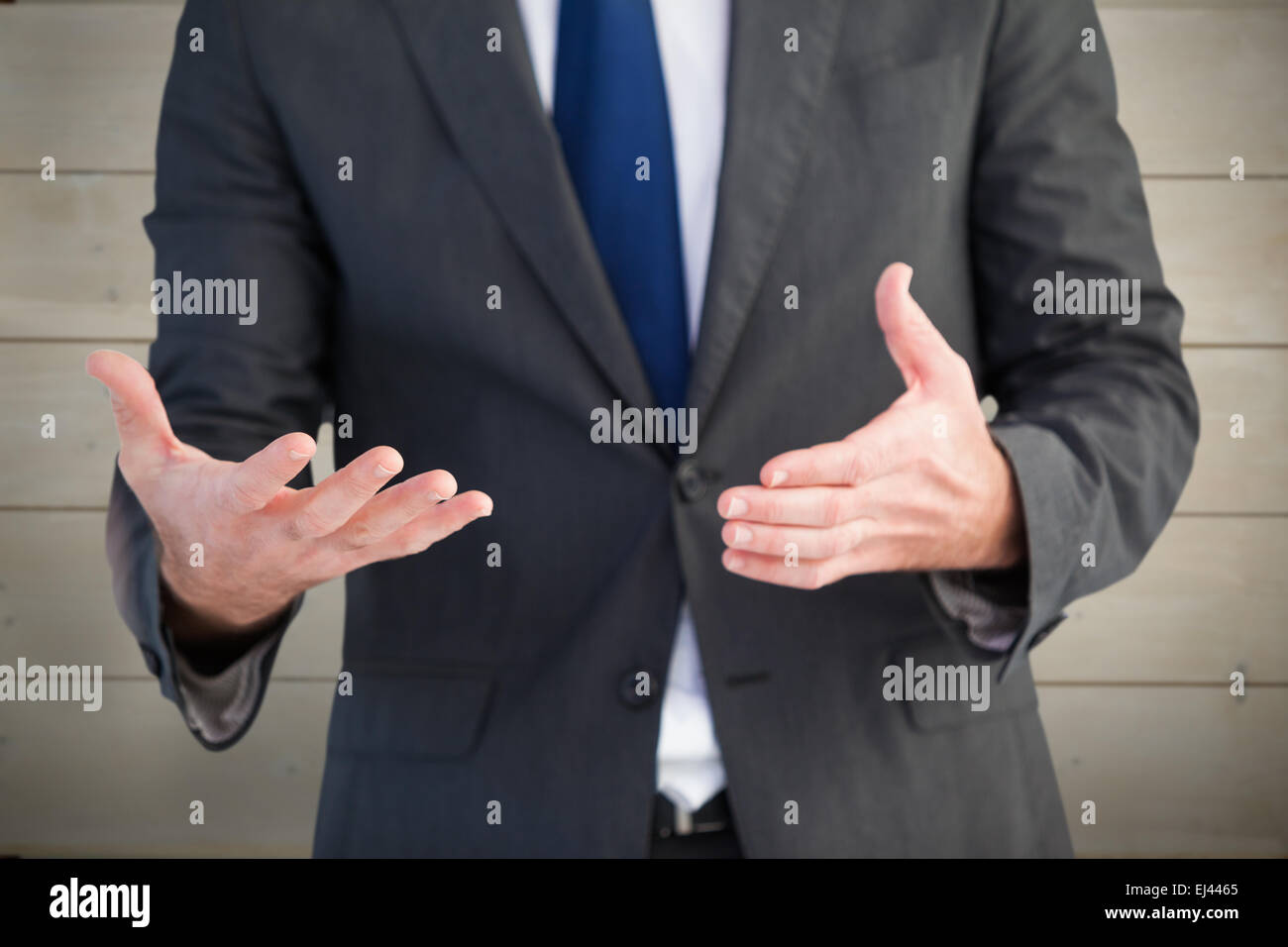 Image composite de handsome businessman presenting with hands Banque D'Images